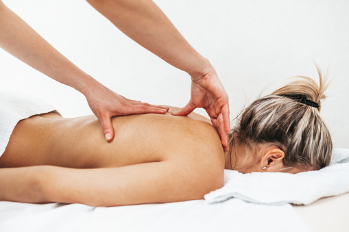 Young adult woman at professional massage treatment.
